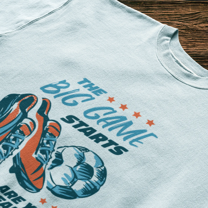 A bold white t-shirt with a hand-drawn football badge of cleats and ball – ideal for football fans and active lifestyles. - Ένα τολμηρό λευκό μπλουζάκι με ένα χειροποίητο ποδοσφαιρικό έμβλημα – τέλειο για φιλάθλους και δραστήριο στυλ.