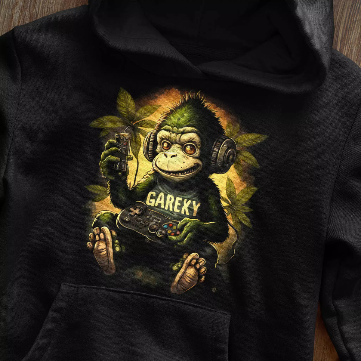 Black pullover hoodie featuring a detailed graphic of a gaming ape with a controller. — Μαύρο φούτερ με κουκούλα που φέρει ένα λεπτομερές γραφικό ενός πιθήκου gamer με χειριστήριο
