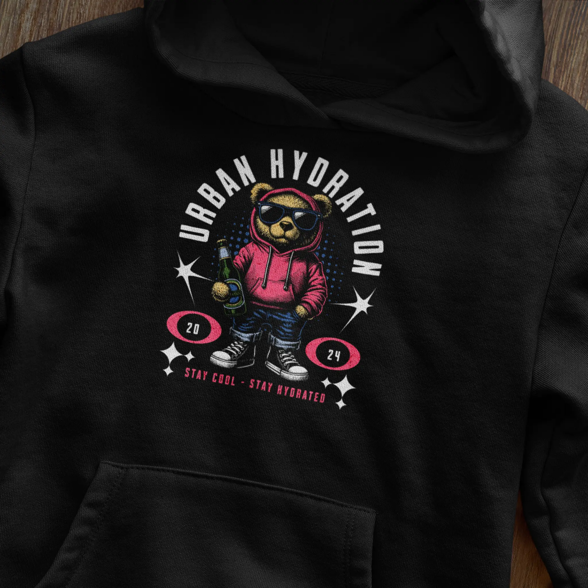 Black pullover hoodie featuring a detailed graphic of a teddy bear with a water bottle. — Μαύρο φούτερ με κουκούλα που φέρει ένα λεπτομερές γραφικό με ένα αρκουδάκι με παγούρι νερού
