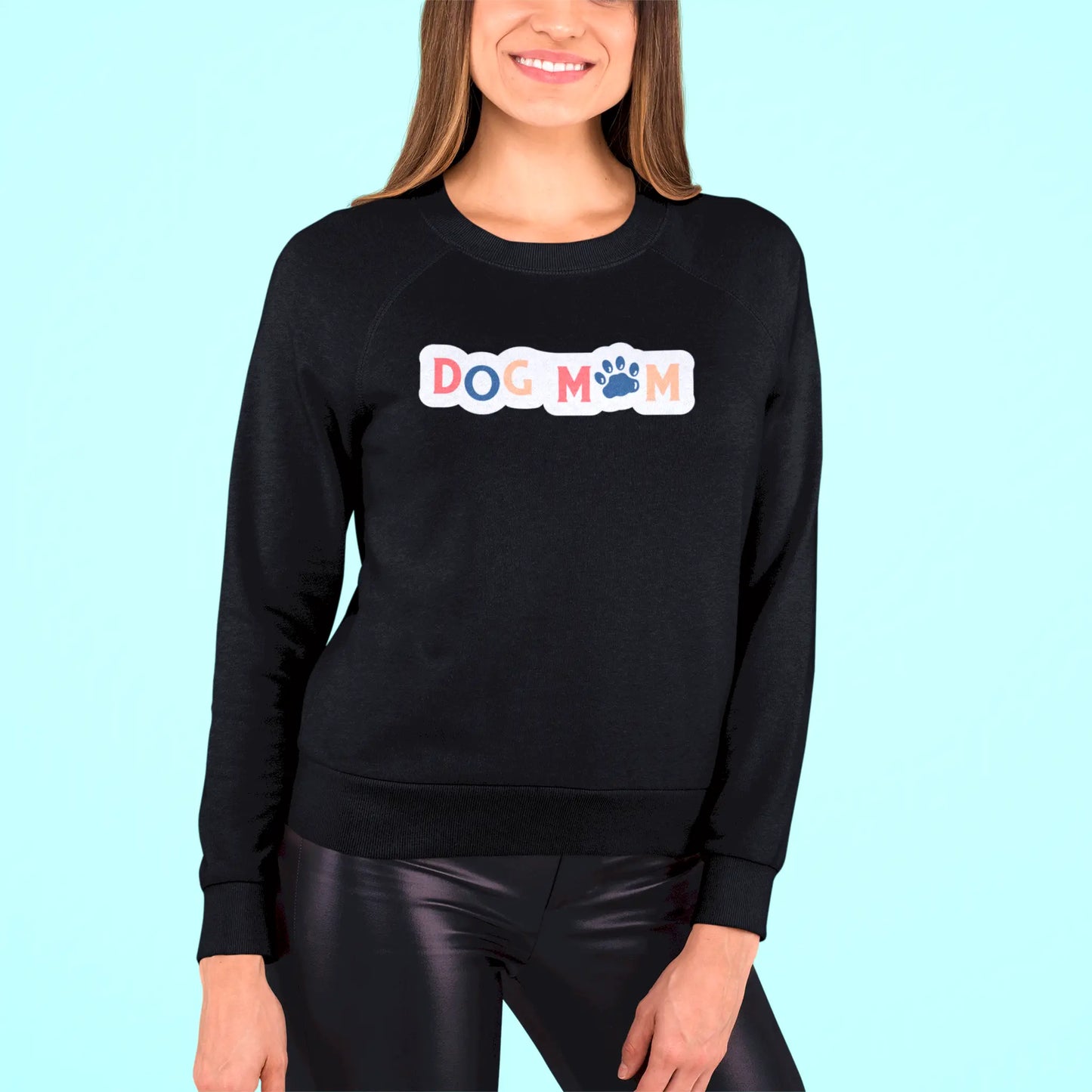 Bold yet heartwarming, the “Dog Mom” design shines beautifully on a black crewneck sweatshirt – Τολμηρό και ταυτόχρονα ζεστό, το σχέδιο “Dog Mom” λάμπει υπέροχα πάνω σε μαύρο φούτερ.