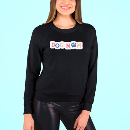 Bold yet heartwarming, the “Dog Mom” design shines beautifully on a black crewneck sweatshirt – Τολμηρό και ταυτόχρονα ζεστό, το σχέδιο “Dog Mom” λάμπει υπέροχα πάνω σε μαύρο φούτερ.