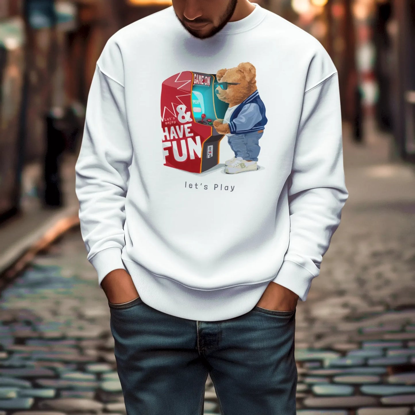 Game On teddy bear on white sweatshirt – Αρκουδάκι μπροστά σε παιχνιδομηχανή “Game On” σε λευκή φούτερ μπλούζα.