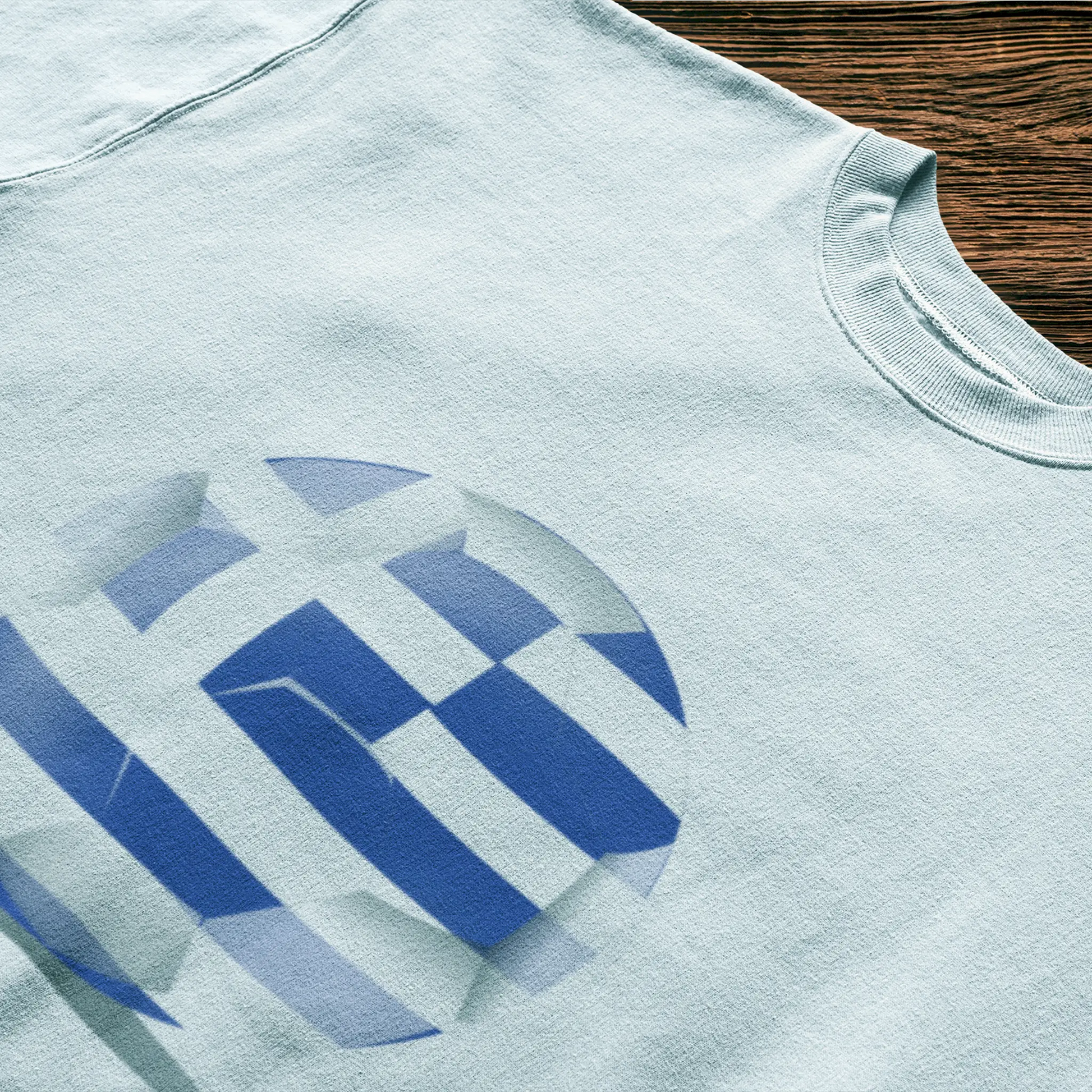 Minimal Greek flag football ball graphic on a clean white t-shirt – Μίνιμαλ γραφικό ελληνικής μπάλας ποδοσφαίρου σε λευκή μπλούζα.