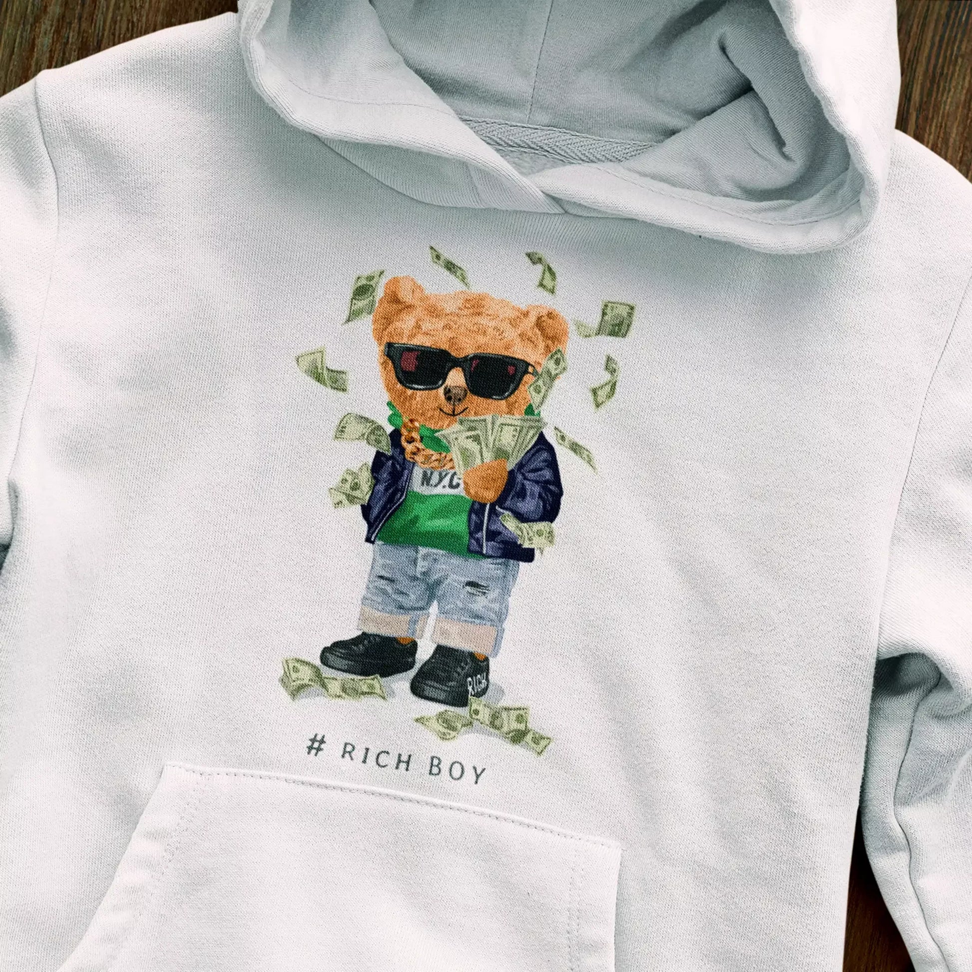 Stylish white fleece hoodie featuring bear flexing wealth – Κομψή λευκή φούτερ με κουκούλα που δείχνει πλούσιο αρκούδο