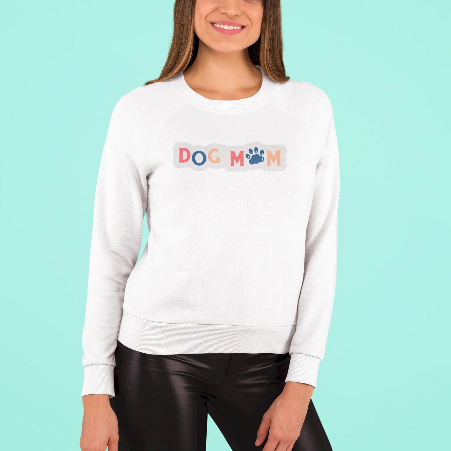 This white crewneck sweatshirt wraps you in softness while broadcasting your dog-mom pride with vibrant charm – Αυτό το λευκό φούτερ σε τυλίγει με ζεστασιά ενώ εκπέμπει περήφανα την ταυτότητα της dog mom με χρώμα και χάρη.