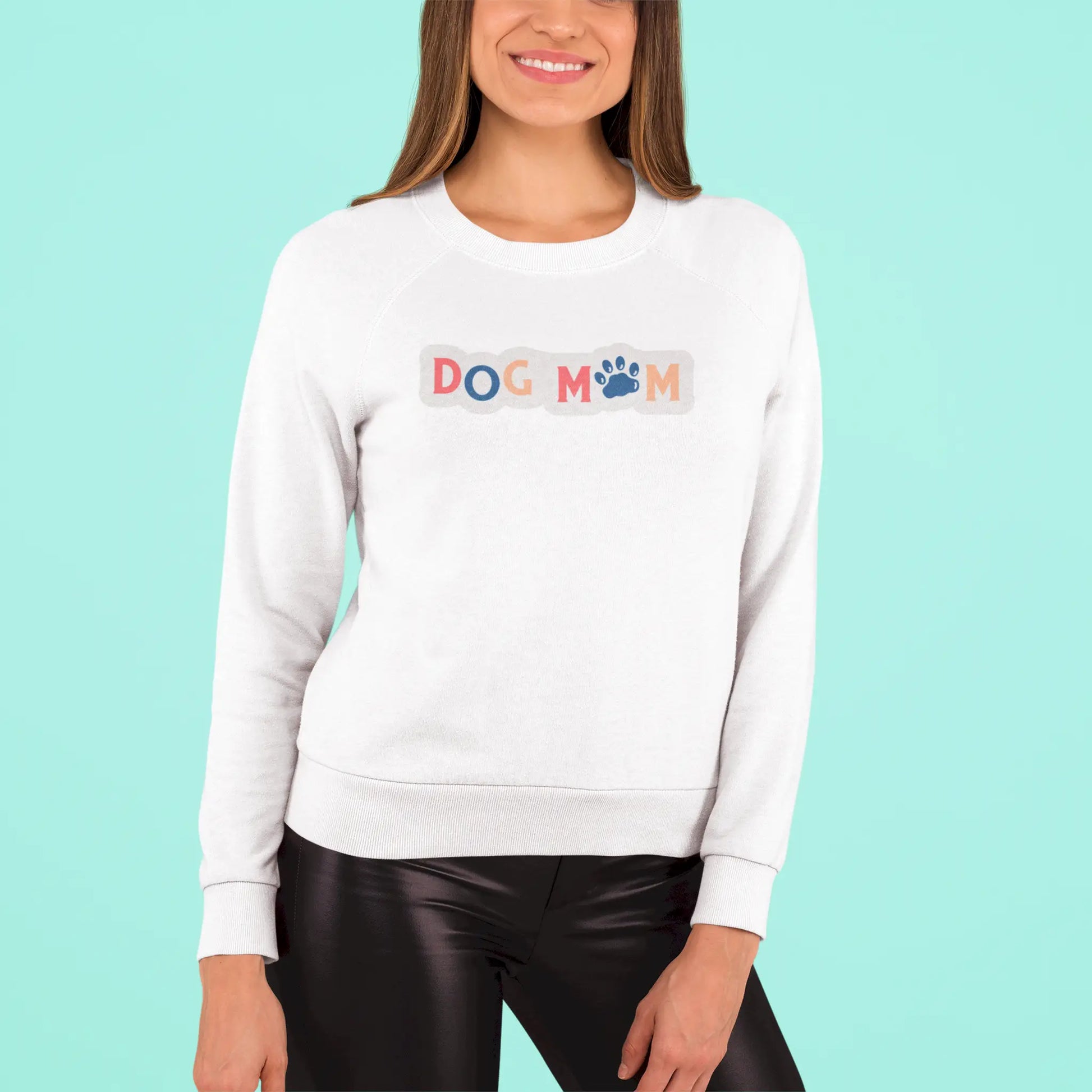 This white crewneck sweatshirt wraps you in softness while broadcasting your dog-mom pride with vibrant charm – Αυτό το λευκό φούτερ σε τυλίγει με ζεστασιά ενώ εκπέμπει περήφανα την ταυτότητα της dog mom με χρώμα και χάρη.