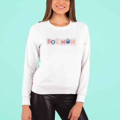 This white crewneck sweatshirt wraps you in softness while broadcasting your dog-mom pride with vibrant charm – Αυτό το λευκό φούτερ σε τυλίγει με ζεστασιά ενώ εκπέμπει περήφανα την ταυτότητα της dog mom με χρώμα και χάρη.