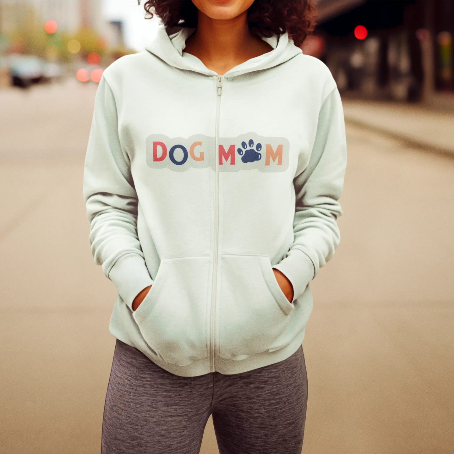 This white zip hoodie offers casual flair while spotlighting your dog mom identity with a colorful twist – Αυτό το λευκό zip hoodie προσφέρει casual στυλ ενώ αναδεικνύει την ταυτότητα της dog mom με χρωματιστή πινελιά.