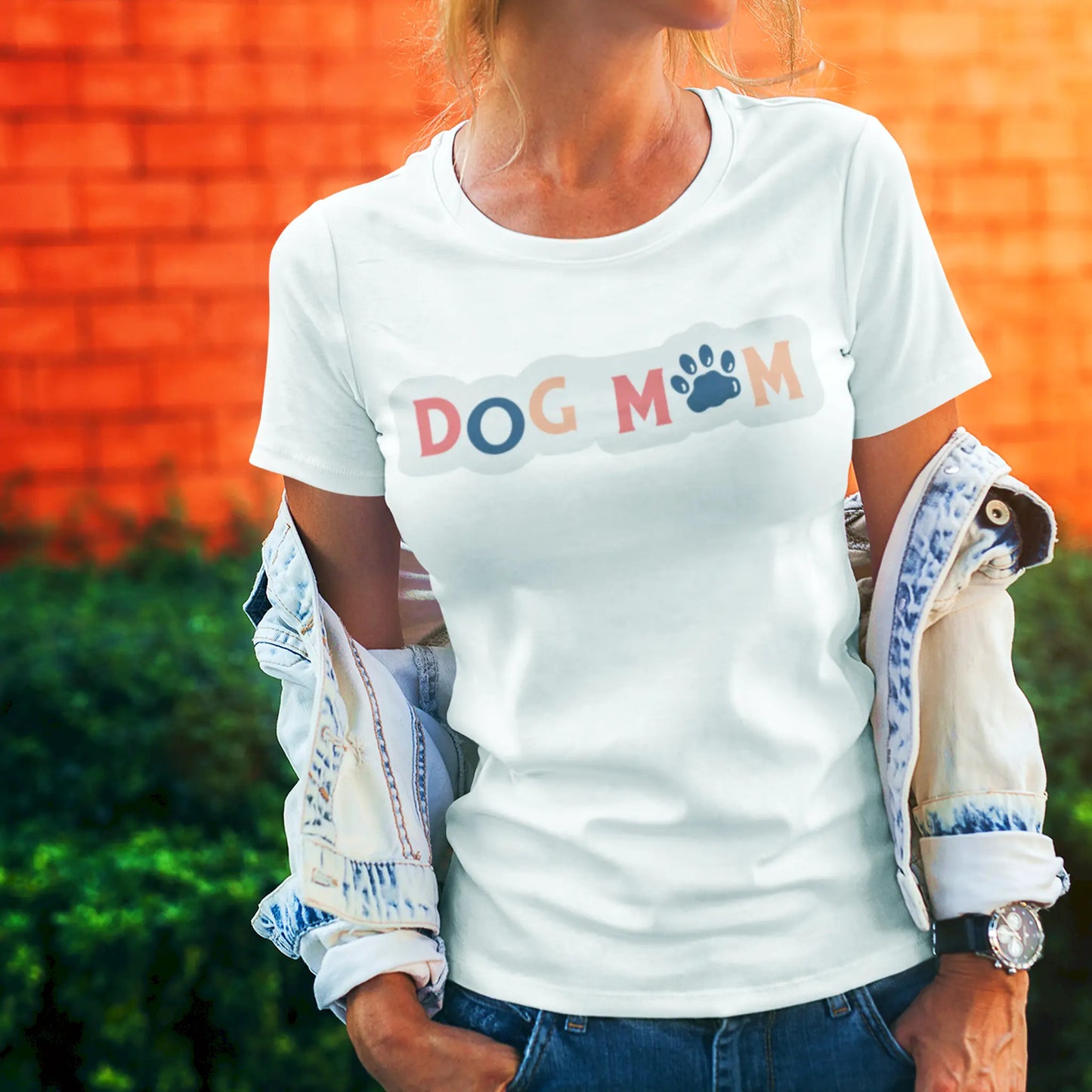 White T-shirt: A colorful “Dog Mom” quote design with a cute paw print replacing the "O", perfect for proud dog moms – Λευκό μπλουζάκι με σχέδιο "Dog Mom" και πατουσάκι, ιδανικό για σκυλομαμάδες