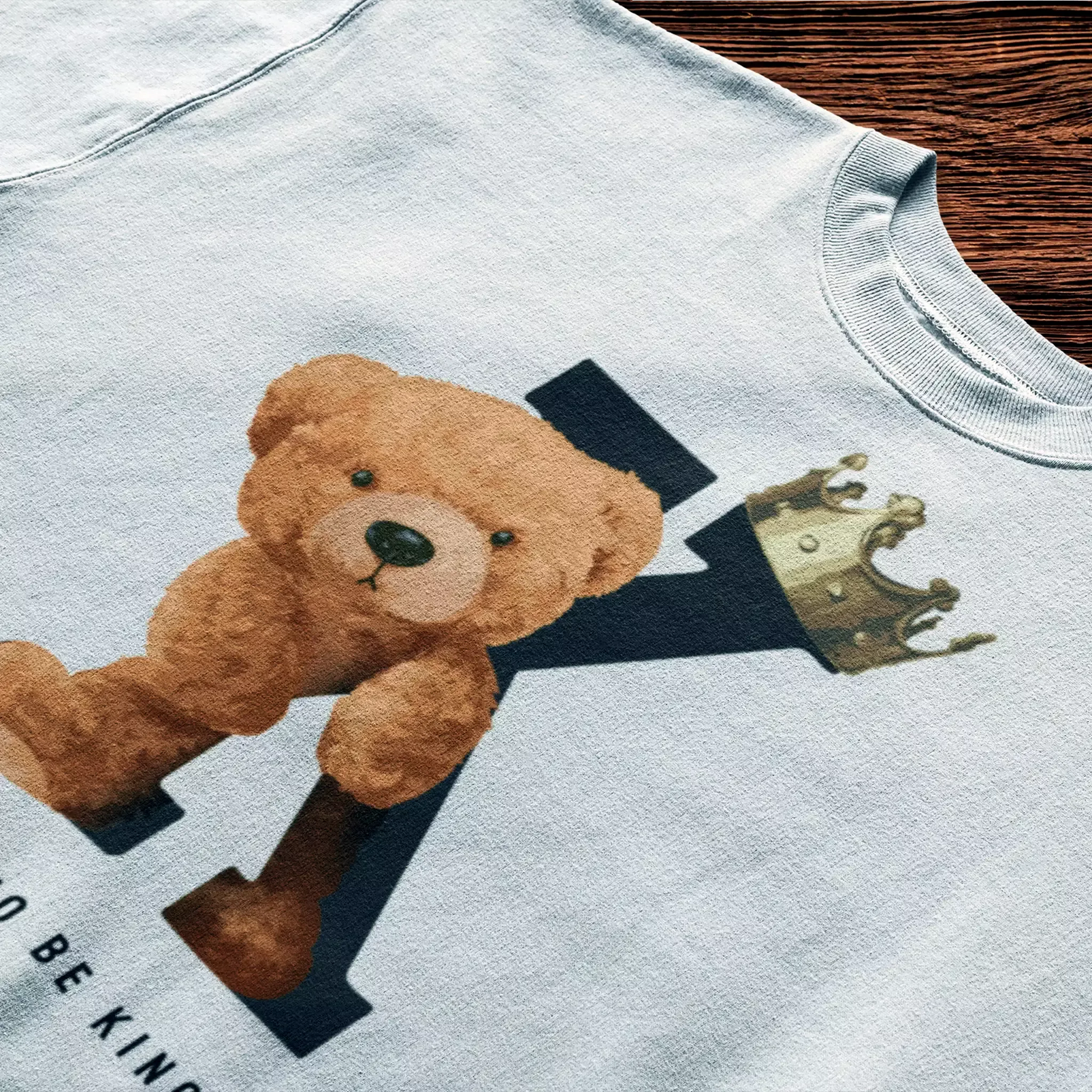 White t-shirt with crown-wearing teddy leaning on bold letter K – Λευκό μπλουζάκι με teddy bear με κορώνα δίπλα στο γράμμα K