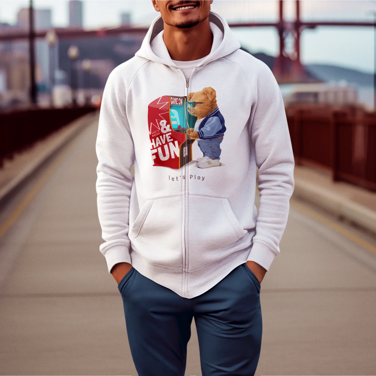 White zip hoodie with teddy next to arcade machine – Λευκή ζακέτα με κουκούλα και αρκουδάκι δίπλα σε arcade.